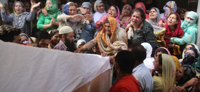 Relatives and neighbors lift the coffin of Waseem Ahmed, a policeman who was killed in a shootout, during his funeral on the outskirts of Srinagar